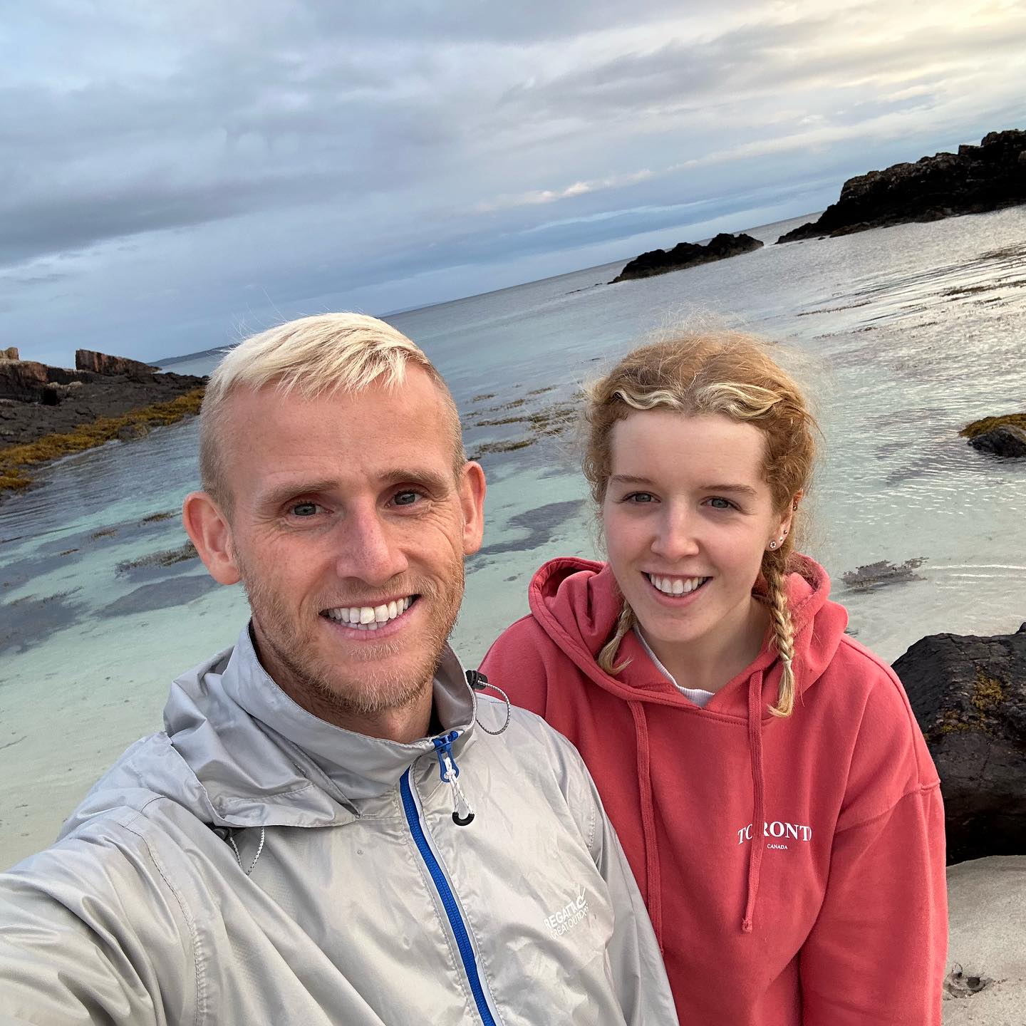Two people taking a selfie beside the beach.